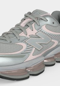 Γκρι και ανοιχτό ροζ αθλητικό παπούτσι New Balance με ύφασμα από δίχτυ, επενδεδυμένη γλώσσα, κορδόνια και μαλακή σόλα με ορατές μονάδες αέρα.