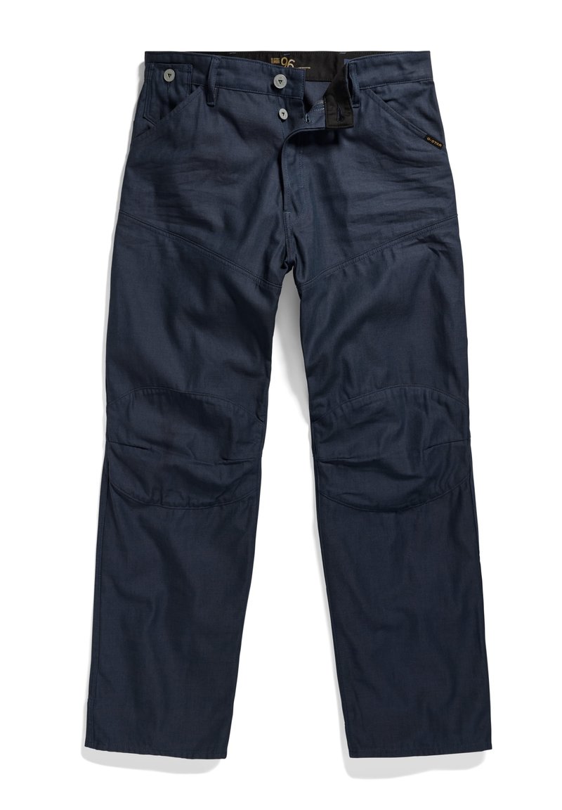 Marineblauwe utilitybroek met versterkte kniestukken, voorzijde met knopen- en ritssluiting, en schuin geplaatste achterzakken, plat gelegd op een witte achtergrond.