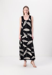 Svart maxiklänning med ett lövmönster i vitt, med rundad halsringning och ärmlös design. Slät tyg och längd till anklarna.