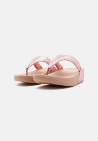 Ροζ πλατφόρμες σανδάλια με λαμπερά λουριά και μαξιλαρωτές σόλες, εμφανιζόμενα από εμπρόσθια γωνιακή όψη σε απλό φόντο.