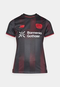 Čierne a červené futbalové dresy pre ženy. Má textúrovanú látku s bodovým vzorom, krátke rukávy a okrúhly výstrih. Obsahuje logá.