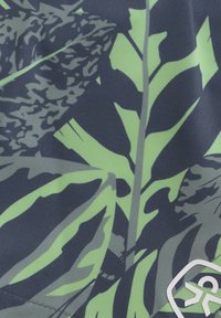 Marinblått tyg med stora gröna och gråa bladmönster, med en strukturerad yta. Innehåller en vit logotyp i det nedre högra hörnet.