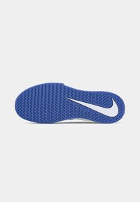 Blaue Nike-Sohle mit Zickzackprofil und großem weißen Swoosh-Logo auf weißem Hintergrund.