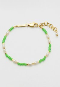 Bracciale placcato in oro con perline verdi sfaccettate, perle bianche e dettagli dorati. Include una chiusura a moschettone e una catena allungata per la regolazione della misura.