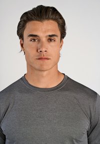 Grå sports T-shirt med rund halsudskæring, med et struktureret mønster. Stoffet virker let og fugttransporterende.