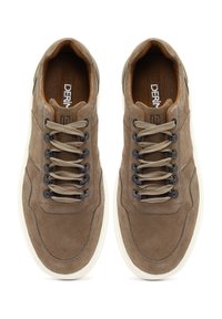 Zapatillas de ante marrón con una superficie texturada, cordones beige y acentos oscuros. Cuenta con una suela de goma blanca y un logotipo en la plantilla.
