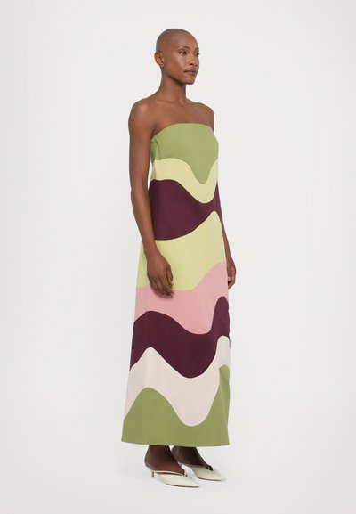 Strapless maxi dress featuring a wavy pattern in green, pink, white, and maroon. Made from fabric with a smooth texture. Stiletto heels.