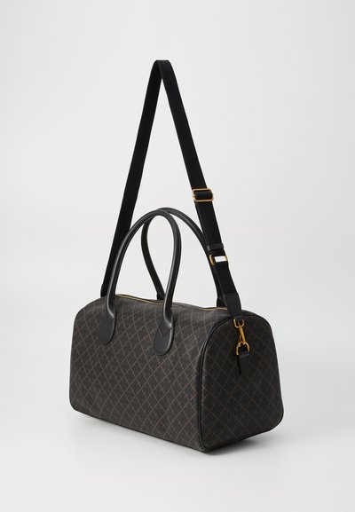 Brown patterned handbag made of textured material; features black leather handles and a contrasting adjustable strap with gold hardware accents.