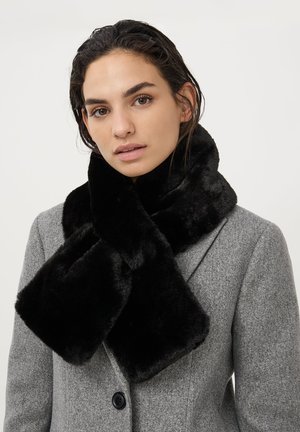 Sciarpa in pelliccia sintetica nera con una texture morbida e un aspetto soffice, indossata sopra un cappotto di lana grigio con dettagli a rever e bottoni.