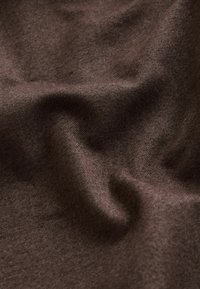 Brunt tyg med en mjuk, texturerad yta, som visar mjuka veck och en enhetlig färg. Inga framträdande mönster eller accenter synliga.