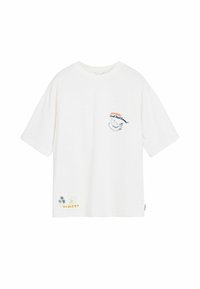 Tricou alb oversized din bumbac, cu un grafic de banană și text pe piept, având palmieri și "Haiti" în partea stângă jos.