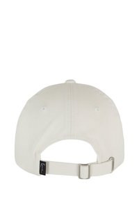 Vit bomull baseballkeps med justerbart band, med en bakmask och ventilationshål för andningsförmåga. Diskret logotypmärke på bandet.
