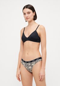 Czarna, trójkątna bielizna typu bralette oraz dół bikini w wężowy wzór z czarnym pasem z logo HUGO, wykonane z gładkiego, elastycznego materiału.