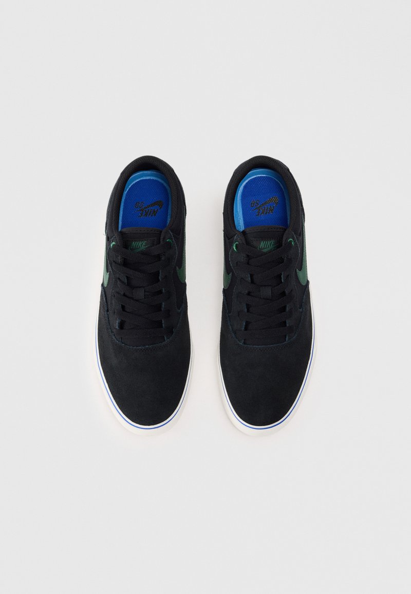 Czarne zamszowe sneakersy z zielonym logo Nike, niebieską wkładką i białą gumową podeszwą. Posiadają klasyczny sznurowany design.