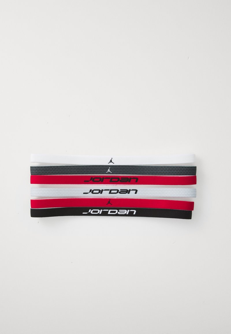 Quatro faixas atléticas em branco, vermelho e preto. Tecido macio e elástico com o logótipo "Jordan" e riscas contrastantes. Cada faixa é plana e suave.