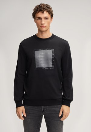 Felpa nera con maniche lunghe, collo rotondo e un motivo grafico rettangolare che presenta il testo "JOOP! JEANS" in varie sfumature di grigio.