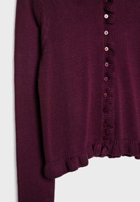 Strickjacke in Burgunderrot mit abgerundetem Saum, die über gerüschte Kanten und eine Reihe dekorativer Knöpfe auf der Vorderseite verfügt.