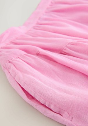 Světlá růžová látková sukně se strukturovaným řasením, vyrobená z měkkého, lehkého materiálu s hladkým povrchem, zdůrazňující její pohodlný a splývavý tvar.