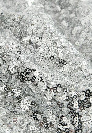 Hõbedane sädelev kude, kus on ringikujulised sädeldavad nurgad erinevates suurustes, luues tekstureeritud, peegelduva pinna, mis näib kortsus.