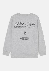 Sweatshirt gris à col rond, à manches longues et avec des poignets côtelés. Présente un texte imprimé noir au dos, incluant des détails sur la marque et la production.