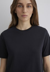 Dark navy t-shirt made of soft cotton fabric, featuring a classic crew neck and short sleeves. Smooth texture with no visible patterns or accents.