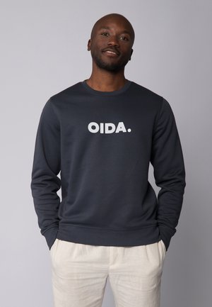 Marineblauwe sweatshirt met lange mouwen, met in het midden een witte opdruk "OIDA." Gemaakt van een zachte, gladde stof.