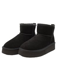 Black suede ankle boots with a soft inner lining, rounded toe, and flat rubber sole. Features minimal stitching and subtle design accents.