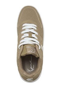 Sneaker beige con superficie testurizzata, lacci bianchi e dettaglio del logo. Presenta una linguetta imbottita e una fodera in rete interna per la traspirabilità.
