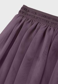 Lila tyllkjol med elastisk midjeband, med lager av genomskinligt tyg som skapar en mjuk och svävande silhuett.