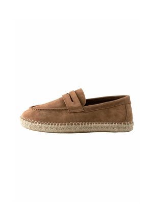 Mocassin en daim marron avec une semelle espadrille en jute tressée et un détail de bride sur le dessus, montré de profil sur fond blanc.