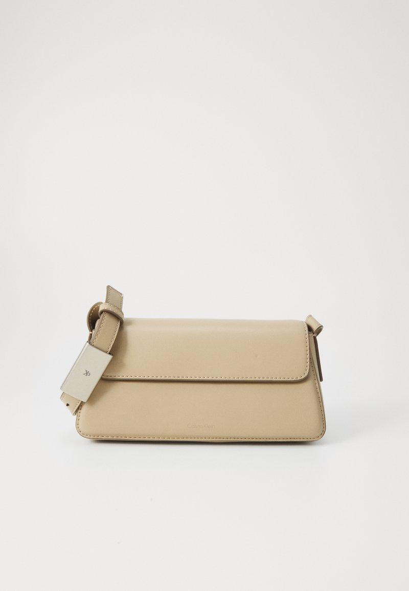 Beige faux leather handbag with a flap closure, adjustable strap, and minimalist design. Features subtle stitching and embossed branding.