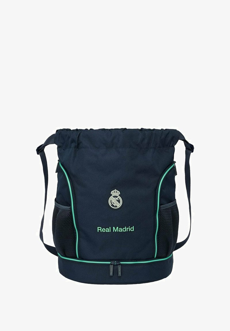 Granatowa torba na sznurek z zielonymi akcentami, z napisem "Real Madrid" oraz logo. Zawiera siateczkowe boczne kieszenie oraz zamykaną na zamek dolną komorę.