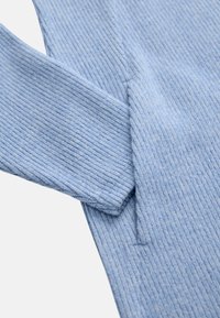 Hellblauer Rippstrickstoff mit sichtbarer Textur und Struktur. Mit langen Ärmeln und einem leicht legeren Schnitt. Keine zusätzlichen Details.