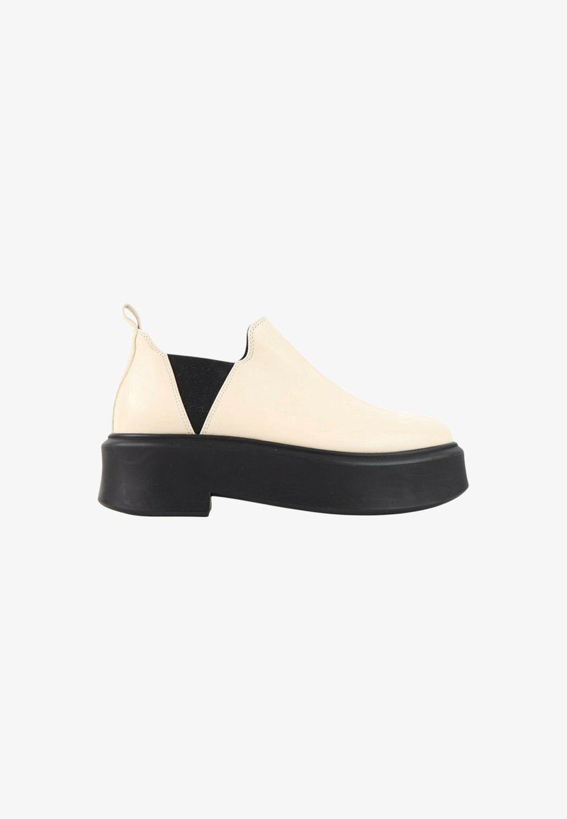 Chaussure crème à enfiler avec panneaux latéraux élastiques noirs et semelle plateforme noire épaisse, vue du côté extérieur.