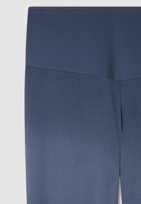 Granatowe legginsy o gładkiej fakturze i wysokim pasie. Materiał ma subtelny połysk i zwęża się ku kostce.