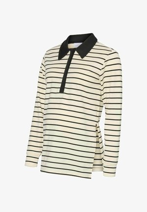 Kreminės spalvos ilgomis rankovėmis polo marškiniai su juodomis juostelėmis, turintys juodą apykaklę ir dalinį priekinių užtrauktuką. Šoninės plyšys, užtikrinantys patogų judėjimą.