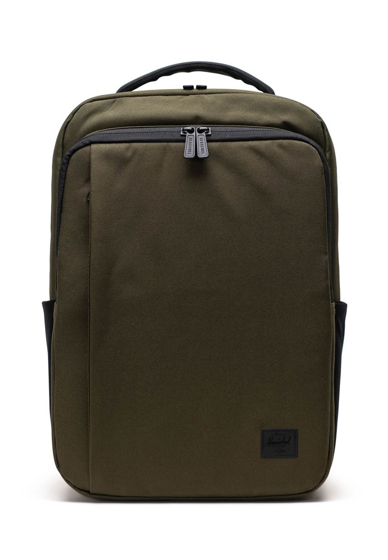Sac à dos vert olive en tissu résistant, avec une texture lisse, des fermetures éclair doubles et un patch de marque noir à l'avant.