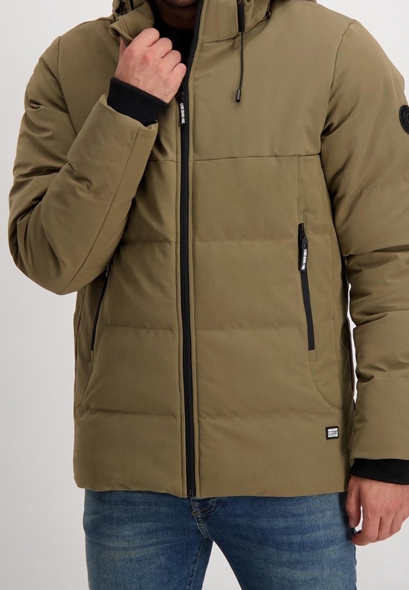 Olivgrön puffjacka med huva, blixtlås framtill, svarta detaljer och två sidofickor. Har quiltat foder för isolering.