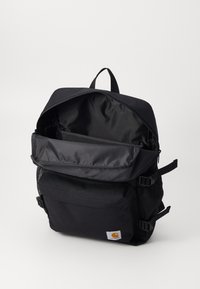 Mochila negra hecha de tela duradera, con un gran compartimento con cremallera, bolsillo frontal, bolsillos laterales de malla y correas ajustables.
