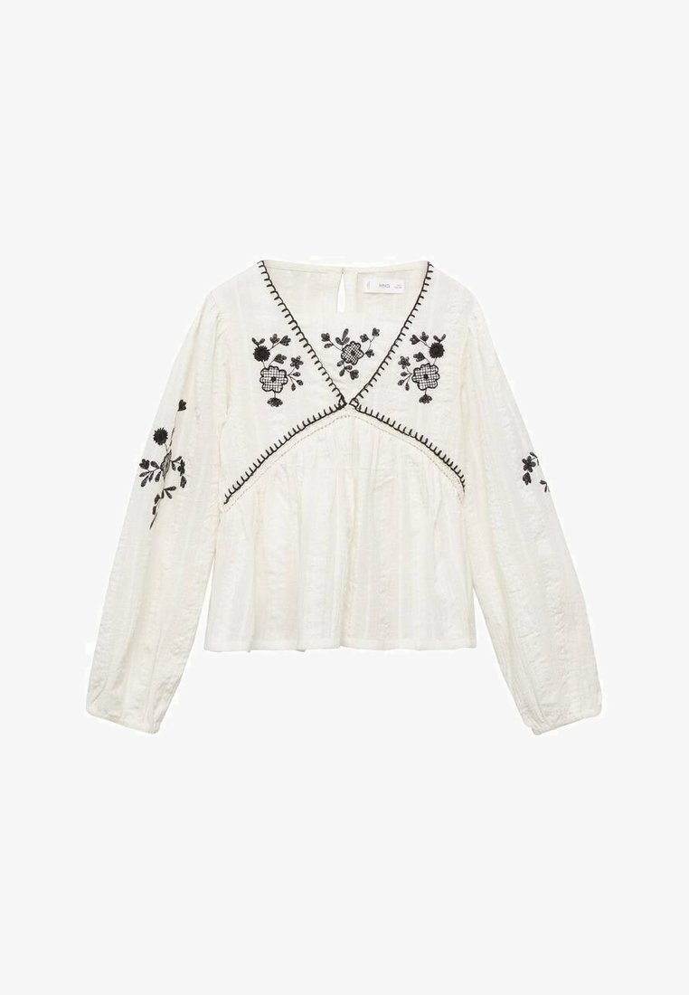 Bela, dolga majica z dolgimi rokavi in V-izrezom, ki ima črne cvetlične vezenine in kontrastne šive. Teksturna tkanina z nabranim dizajnom.