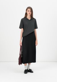 Pilka polo marškiniai, klostuota juoda sijonas, juodi batai, šviesiai pilkos kojinės, bordo rankinė. Paprastas dizainas, lygus tekstūra, neutralios spalvos.