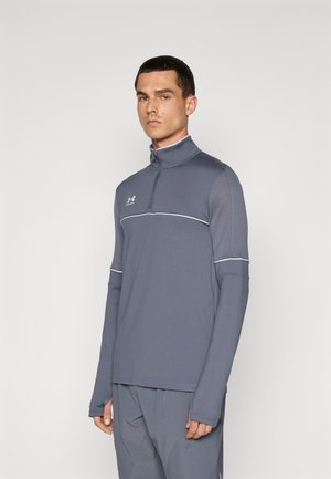 Gray long-sleeve pullover with a high collar, featuring a zip closure, white accent stripe, and stretch fabric for mobility.