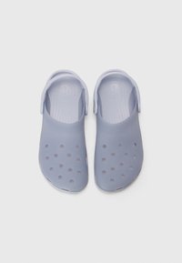 Light purple rubber clogs with a slip-on design, ventilation holes, and a back strap for secure fitting. Textured insoles for comfort.