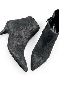Botines de ante negro con punta afilada, tacón de 7,5 cm y cremallera lateral. Textura suave con un ligero brillo y diseño minimalista.