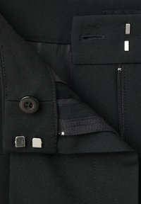 Zwarte stoffen kleding met een knoop, metalen accenten en een zipper pocket. De textuur lijkt glad met een op maat gemaakt afwerking en gestructureerd ontwerp.
