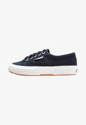Zapatillas deportivas de lona navy con suela de goma blanca, punta redonda y diseño de cordones con seis ojales. Presenta una superficie texturizada y una etiqueta de la marca en el lateral.