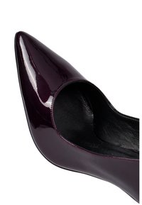 Zapato de tacón alto púrpura brillante con punta afilada y un corte lateral abierto. Interior de cuero negro con costuras a lo largo de los bordes.