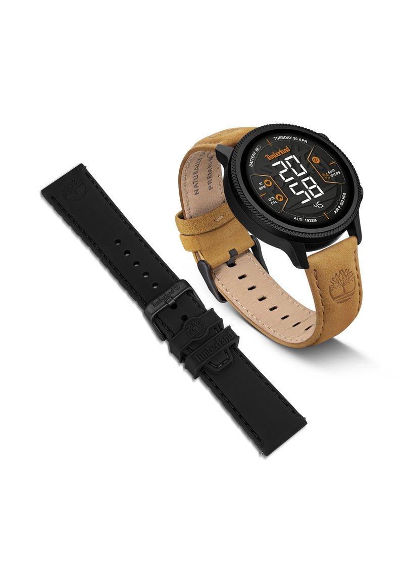 Digital watch with a black circular case and tan leather strap. Includes a black silicone strap. Features a black digital display with orange accents.