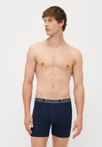 Boxer-culottes bleu marine avec une texture douce et une taille élastique arborant le texte "PIER ONE" en blanc. Design ajusté, longueur mi-cuisse.