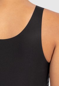 Prenda negra sin mangas con una tela suave y texturizada, que presenta un escote redondeado y tirantes anchos, ajustada al cuerpo.